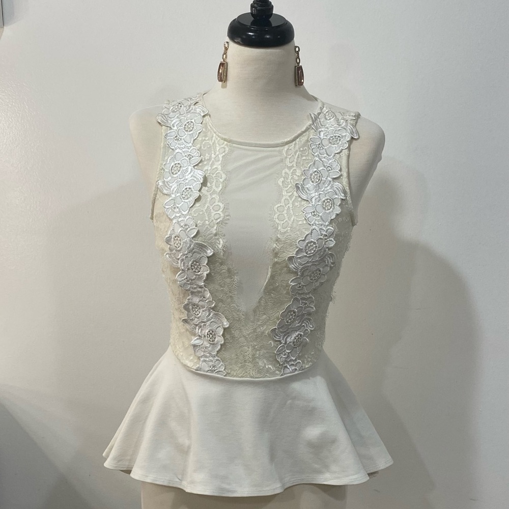 Super adorable lace & appliqué peplum top by bebe lace is more of an ivory color